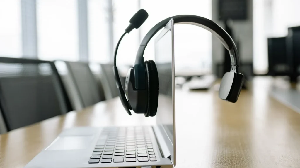 Wireless headset resting on a laptop in a bright office, ready for VoIP calls