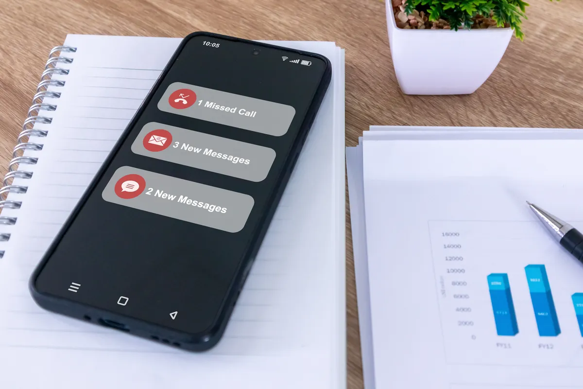 Smartphone on a desk showing a missed call and new messages