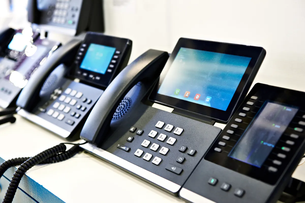 Modern IP desk phones with colour touchscreens and a key expansion module