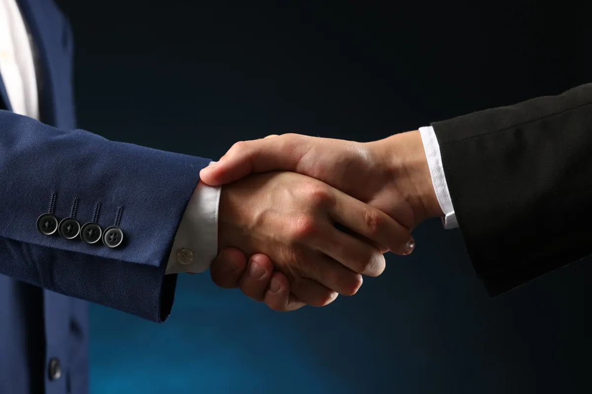 Two business partners shaking hands to join the CloudLine VoIP reseller program